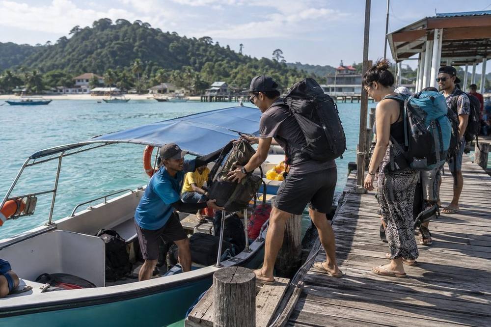 Backpacks loaded onto a small boat at a Malaysian ferry jetty